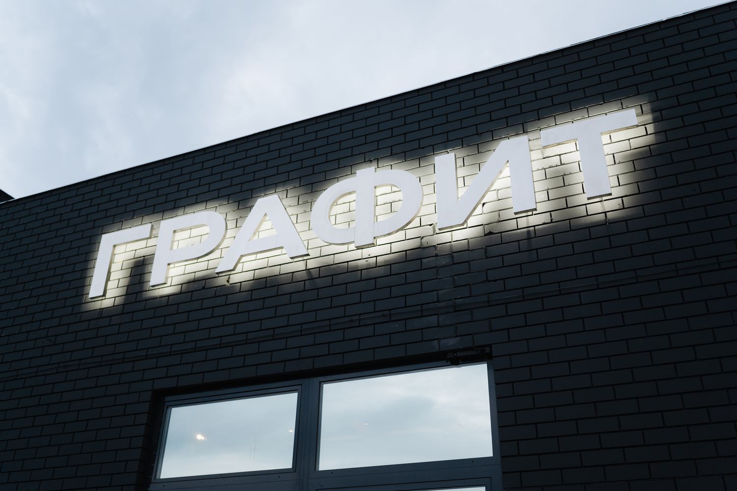 Светящаяся вывеска ГРАФИТ на фасаде здания